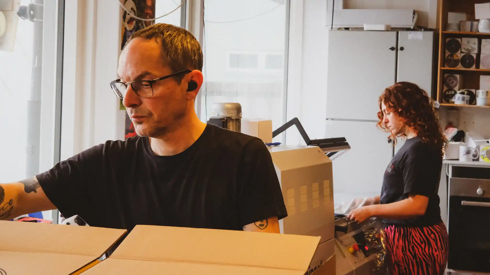 Production assistants, Azahar and Daniel, shrinkwrapping records