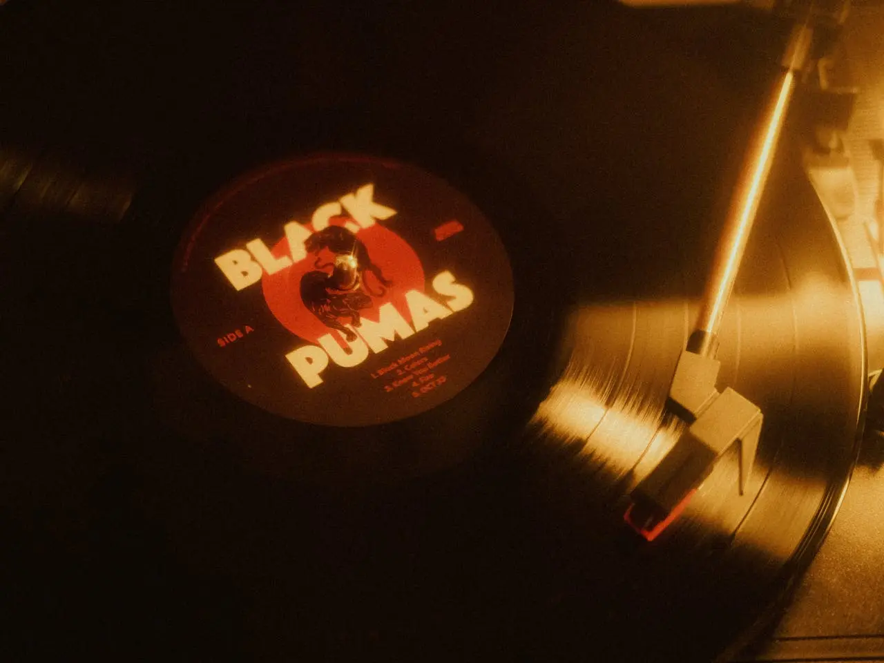 A grainy image of a Black Pumas vinyl record being played.