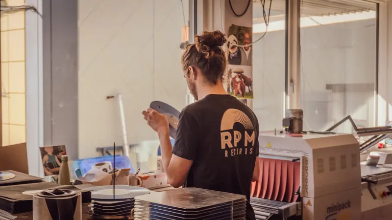 Mathias, RPM Records COO, inspecting a record he just pressed