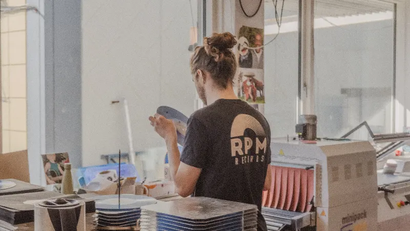 Mathias, RPM Records COO, inspecting a record he just pressed